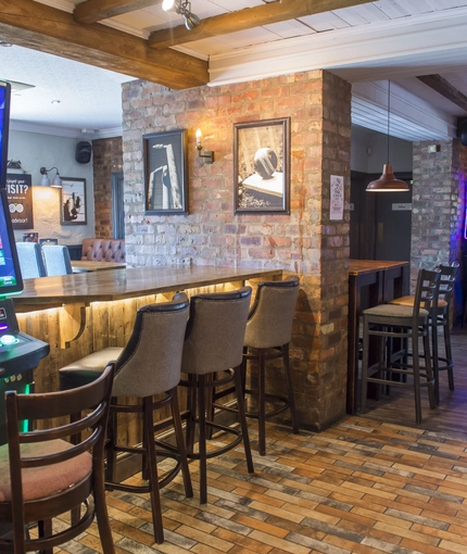 Interior dining area of a pub with gambling machines.