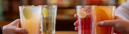 A group of people sitting at a table holding mocktails