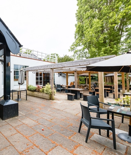 Exterior facade and seating area of a pub.