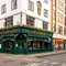 The exterior facade and signage of The Golden Lion in Soho, with a large clock on the wall and flower boxes at the upper windows.