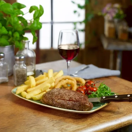 Sirloin steak, chips, onion rings and a glass of red wine