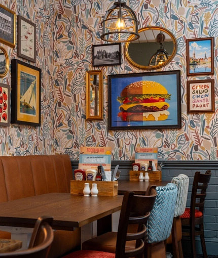 The interior restaurant seating area at The Man On The Moon, with upholstered booth seating and framed artwork on the wall.