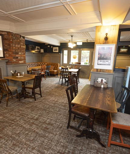 Interior dining area of a pub with a fireplace.