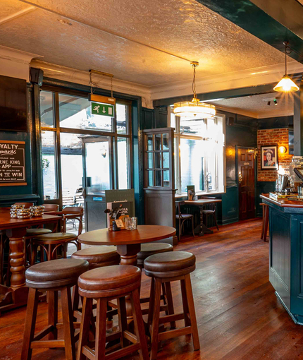 The interior bar and restaurant seating area with TV screen and advertising chalkboard at The Lucas Arms.