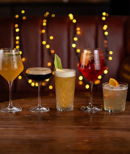 a few drinks sitting on a wooden table of a pub