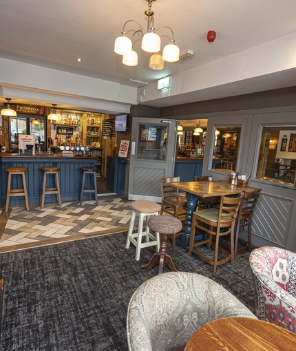 Interior dining area and pub area of a pub with a TV.