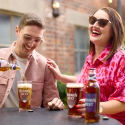An image of 2 people enjoying Belhaven Best within the exterior beer garden seating area.