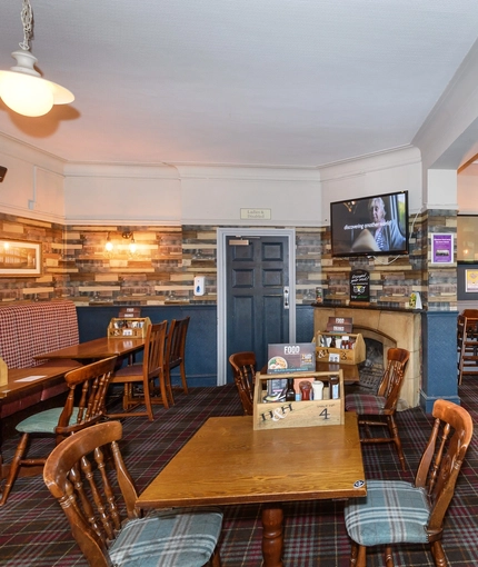 Interior dining area of a pub with a few TVs.