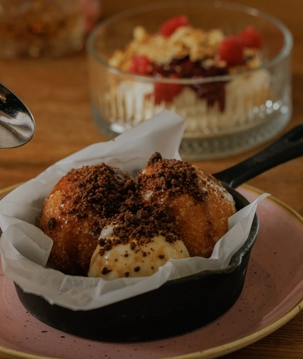 A lifestyle image of 2 dessert dishes from the Burns Night menu sat on a table within the interior restaurant seating area at The Crown.