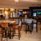 The bar and interior restaurant seating area of The Parsonage in Leigh, with TVs on the walls.