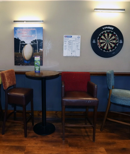 Interior dining area of a pub with a few dartboards.