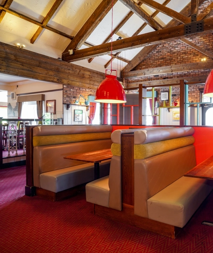 Interior dining area of a pub with a TV.