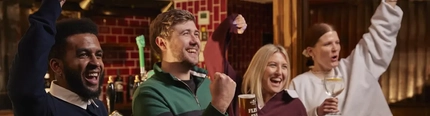 People stood at bar cheering