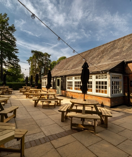 An image of the exterior beer garden seating area with the venue in the background at The Old Red Lion.