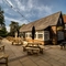 An image of the exterior beer garden seating area with the venue in the background at The Old Red Lion.