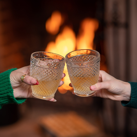 Two hands holding Glenfidditch cocktails and cheersing.