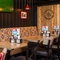 An interior restaurant seating area at The Amington in Tamworth; with a long, upholstered booth seat along one side of the room, and a TV on the wall above it.