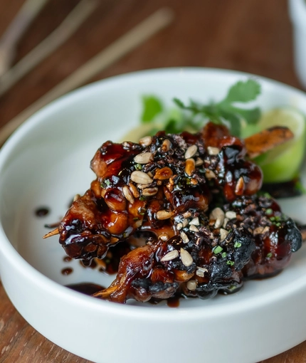 Teryaki chicken skewers, toasted seed and puffed rice, with sunflower seed satay served in a side dish