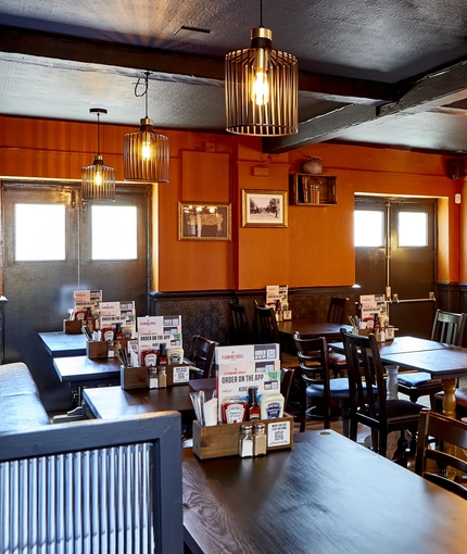 The interior restaurant seating area with TV, at The Good Intent in Hornchurch.