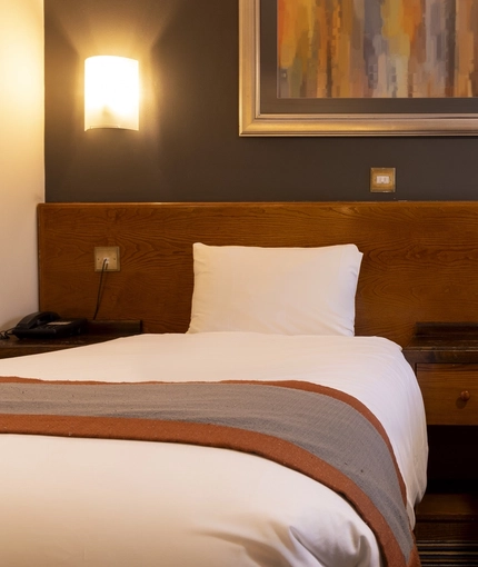 The beds, bedside tables and wall lights in a hotel room at The Weathervane.