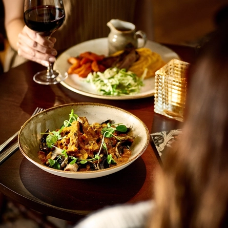 An interior image of 2 customers with 2 Main Autumn Specials dishes available at Chef & Brewer venues.