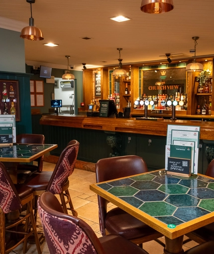 The interior bar and restaurant seating area with tables and chairs at The Church View Inn.
