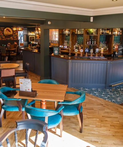 The interior bar and restaurant seating area with TV at The Hare & Hounds.