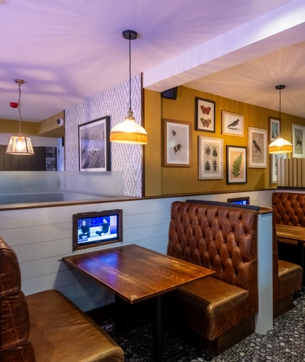 Interior dining area of a pub with a TV.