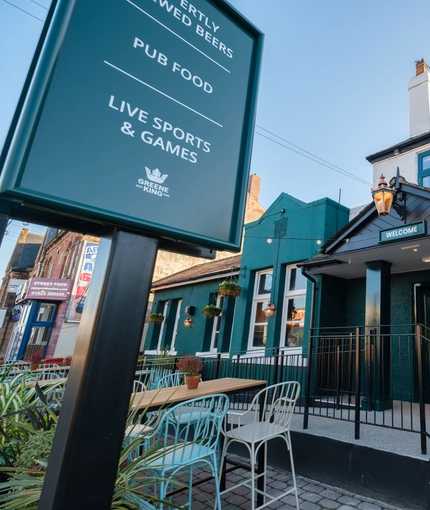 A close up view of the exterior facade, signage, and seating area of The Talbot Inn in Mansfield.