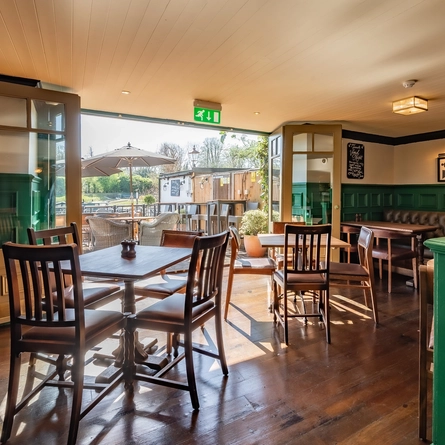 The interior seating restaurant area inside The Magpie with view looking out to the exterior beer garden seating area.