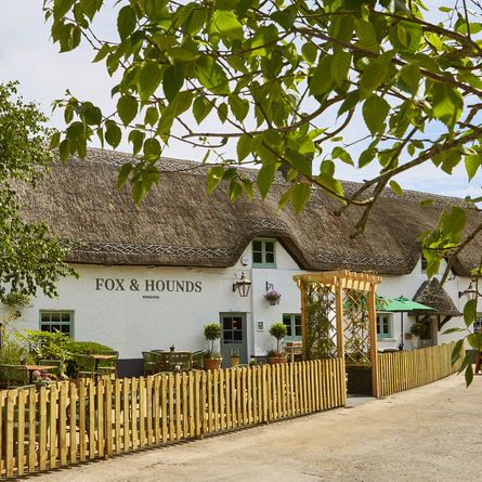 The exterior facade and beer garden seating area of The Fox & Hounds in Wimborne.