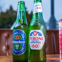 Bottles of Heineken and Peroni low alcohol beers sitting on a table.