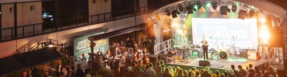 An image of the crowd watching a performance on the exterior Live Event Stage at The Untapped Live At Your Local Final at The Coach House At The George.