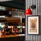 A close up view of one of the interior restaurant tables in the bar area of The Bramford Arms, with menus and condiments in a small wooden box on the table, and a framed piece of art on the wall above it.