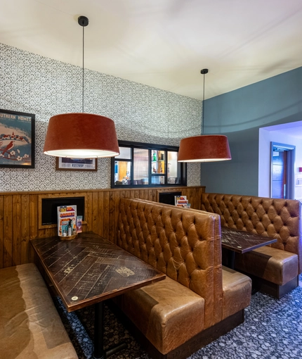 Interior dining area of a pub with TVs and a claw machine.