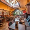 The interior restaurant seating area with tables, chairs, cushioned seating, seating booths, exposed brickwork and ornate chandelier lighting at The Duke Of Sussex.