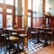 The interior restaurant seating area at the Rhoderick Dhu in Glasgow; with wood panelled walls, upholstered booth seating, and a TV on the wall.