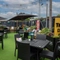 The exterior beer garden seating area at The Royal Oak; with shade umbrellas, and string lights overhead.