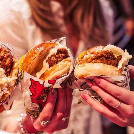 An image of 3 people enjoying burgers available at The Red Dog Saloon, Worlds End.