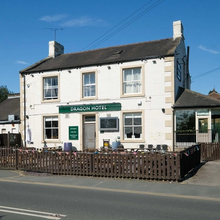 The outside of the Dragon, with a beer garden in front of it.