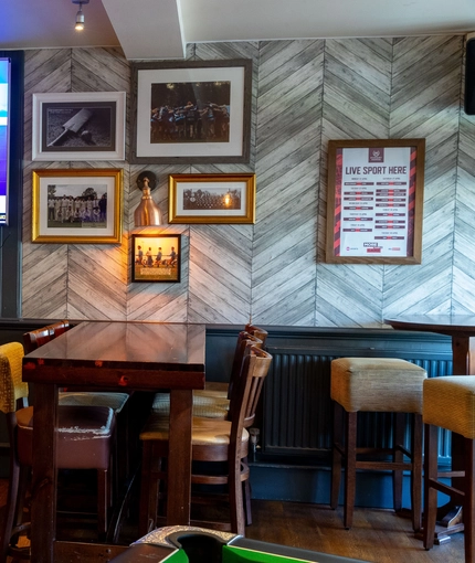 Interior dining area of a pub with a TV.