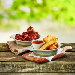 a side of fries in a bowl with ketchup and a side of wings in a bowl.