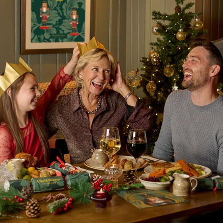 A banner showing a family sat at a table enjoying drinks and Christmas Day dishes at a Chef & Brewer venue.