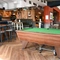 Interior dining area of a pub with a pool table and a gambling machine.
