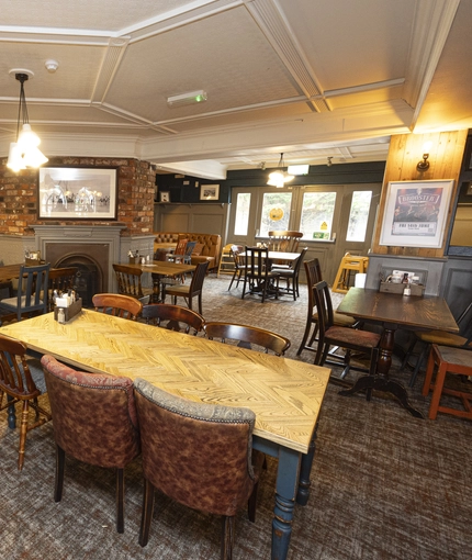 Interior dining area of a pub with a fireplace.