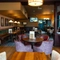 The interior restaurant seating area at The Richmond Arms in Bournemouth, with upholstered chairs and booth seating; and a TV on the wall.