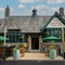 The exterior facade of the venue with hanging baskets, wooden benches and barrel planters at The Church View Inn.