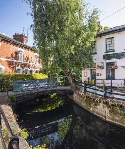 The exterior facade and waterside at The Crown & Horseshoes.