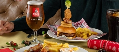 An interior shot of people celebrating Christmas and enjoying festive food in the restaurant/seating area at a Flaming Grill venue.