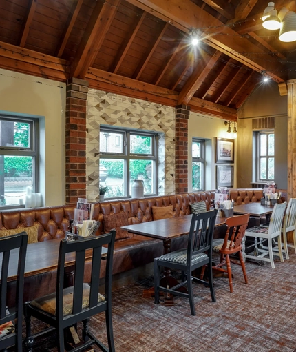 Interior dining area of a pub with a fireplace.